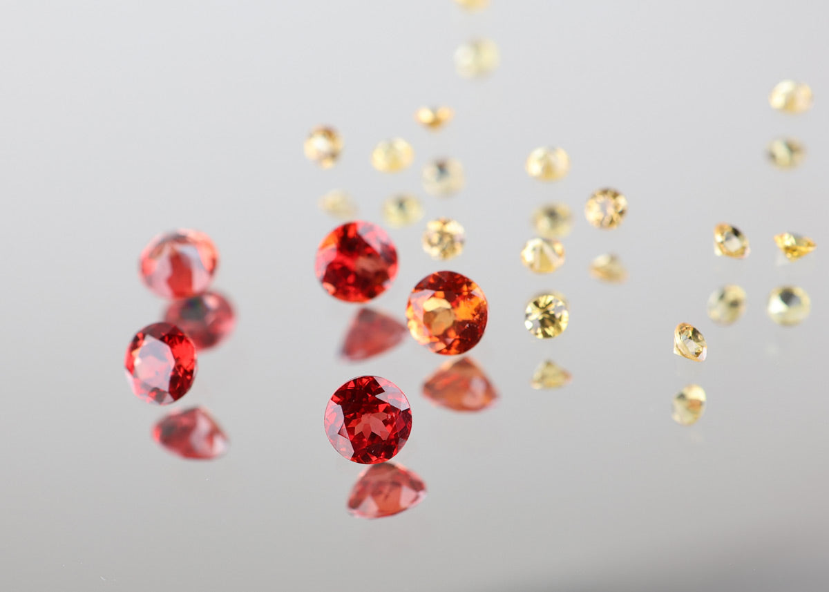 Many gemstones different colours spread on a white background