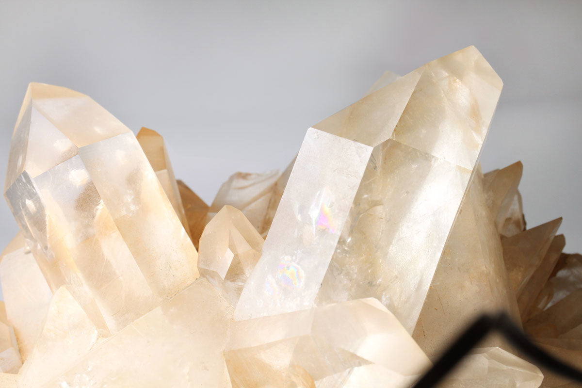 Close-up of tangerine quartz cluster formations on a gray background